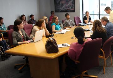 People sitting around a board room table having a meeting.